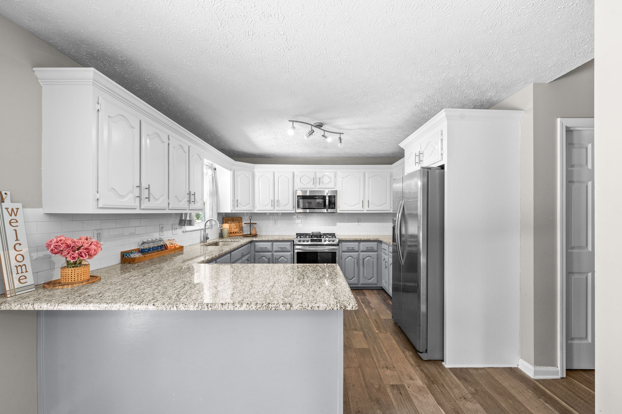 4178 Highway 49 Tennessee Ridge, TN 37178 - Photo 17 of 38 a kitchen with stainless steel appliances granite countertop a refrigerator a stove a sink and dishwasher with wooden floor