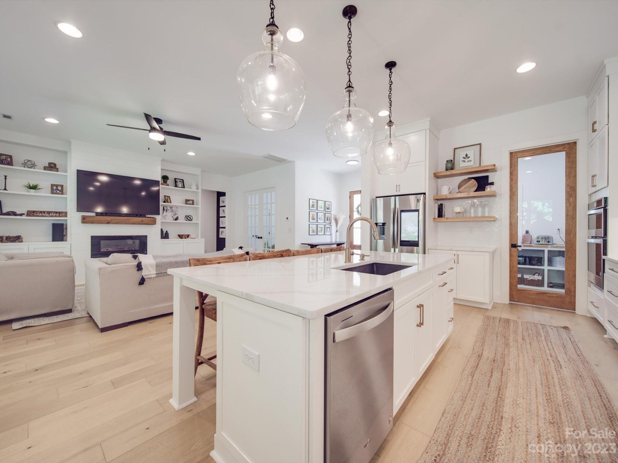 626 Deese Road Monroe, NC 28110 - Photo 14 of 41 a large kitchen with cabinets a sink dishwasher a stove and a dining table with wooden floor