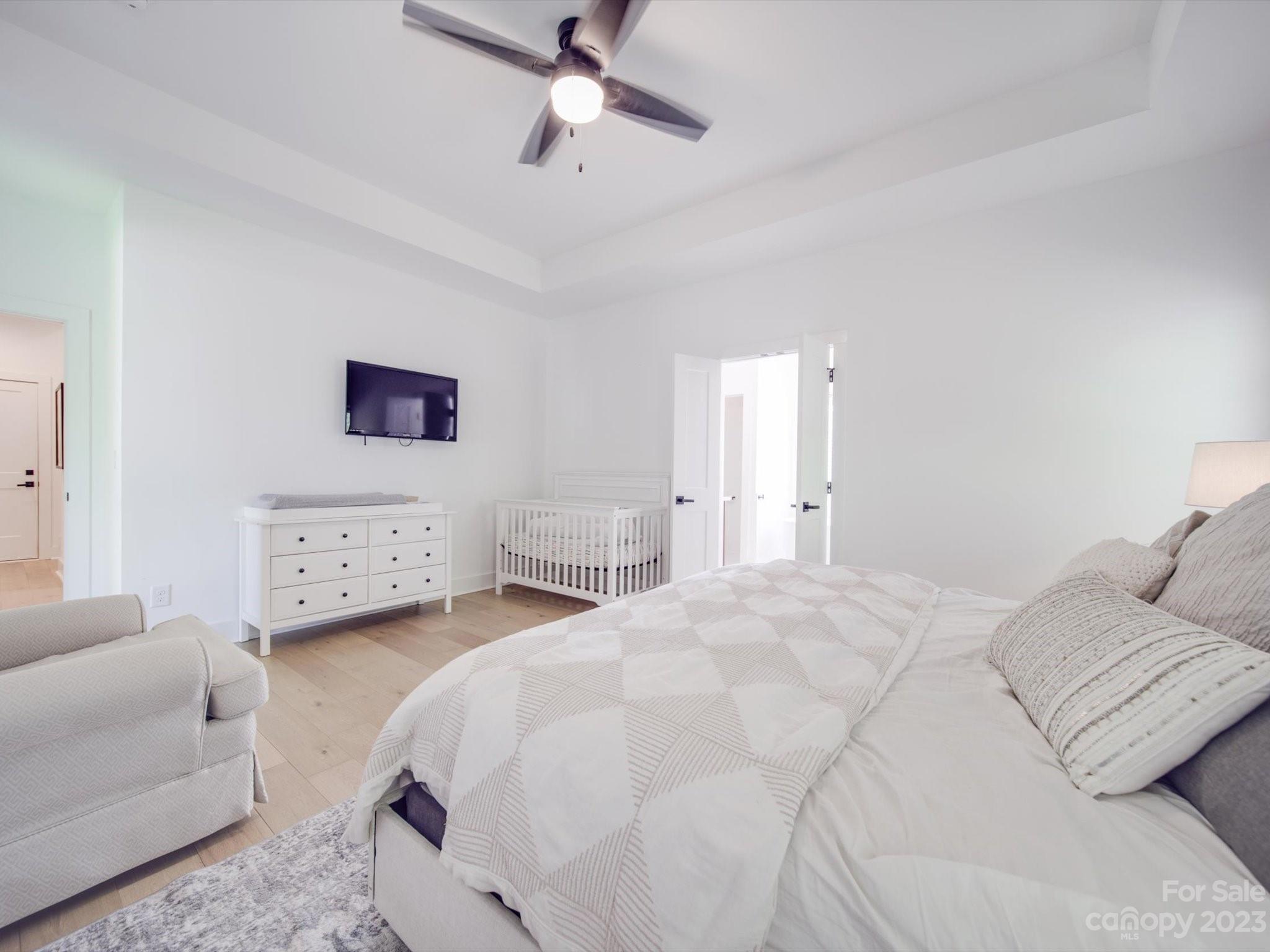 626 Deese Road Monroe, NC 28110 - Photo 25 of 41 a spacious bedroom with a bed a couch and a chandelier