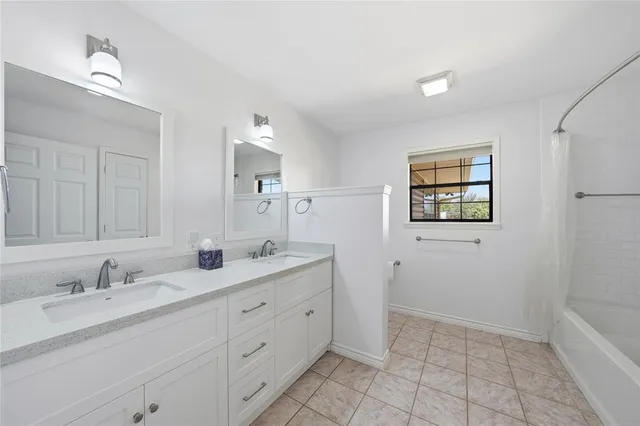 a bathroom with 2 sink tub and a mirror