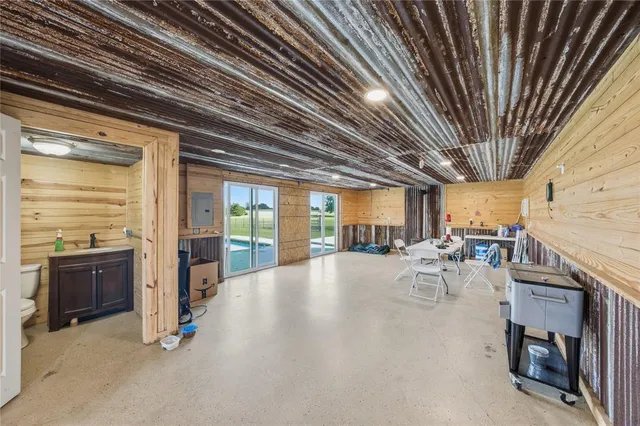 a view of a patio with table and chairs a barbeque with wooden floor and roof