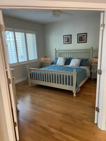 a view of a bedroom with wooden floor and windows