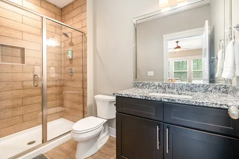 a bathroom with a granite countertop sink toilet and shower