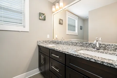 a bathroom with a granite countertop sink and a mirror