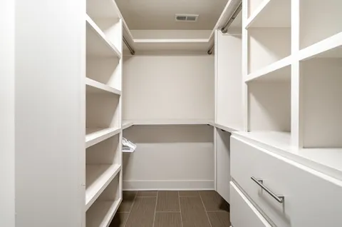 a view of walk in closet with empty racks