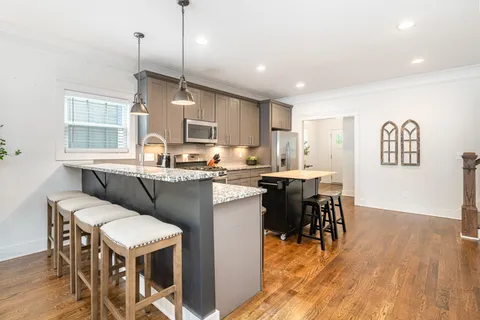 a kitchen with a table chairs refrigerator and microwave