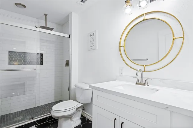 a bedroom with a bed a chandelier and dresser