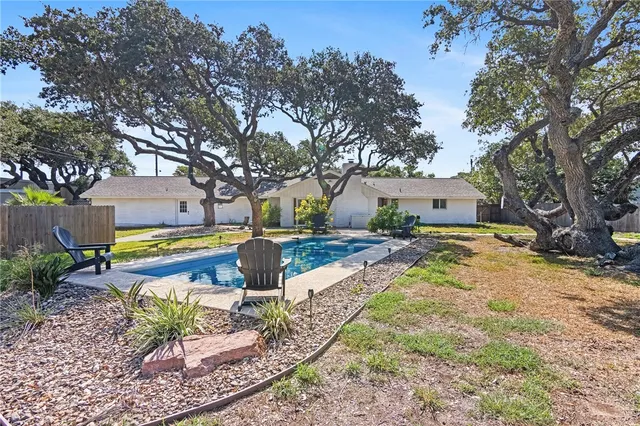 a large kitchen with kitchen island a dining table chairs and white cabinets