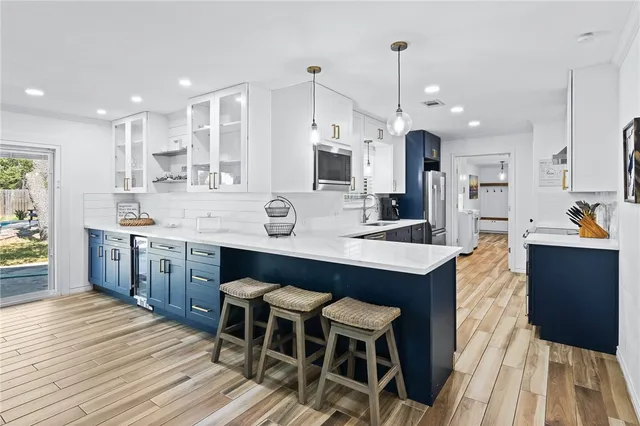 a large kitchen with stainless steel appliances granite countertop a sink stove and refrigerator