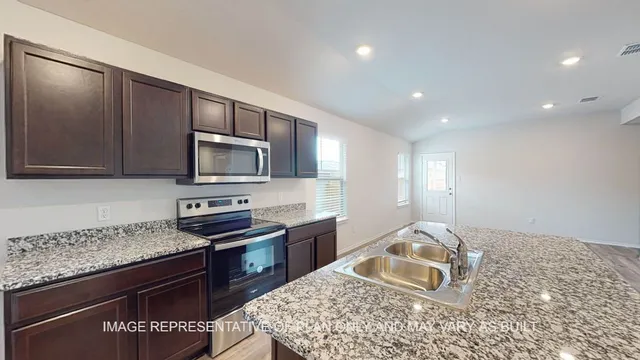 a kitchen with stainless steel appliances granite countertop a sink stove and microwave