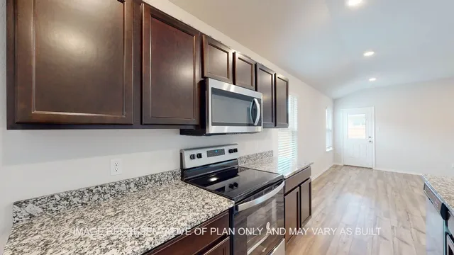a kitchen with stainless steel appliances granite countertop a stove a sink and a microwave