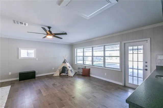 a living room with hardwood floor and a window