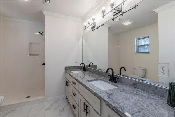 a bathroom with double sink and a mirror