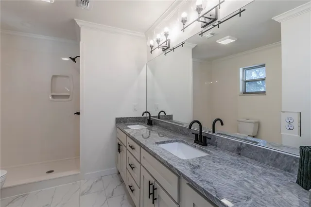 a bathroom with double sink and a mirror