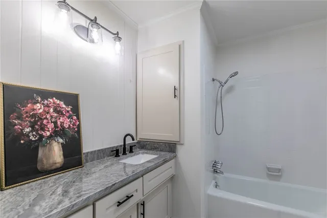 a bathroom with a granite countertop sink a mirror and shower