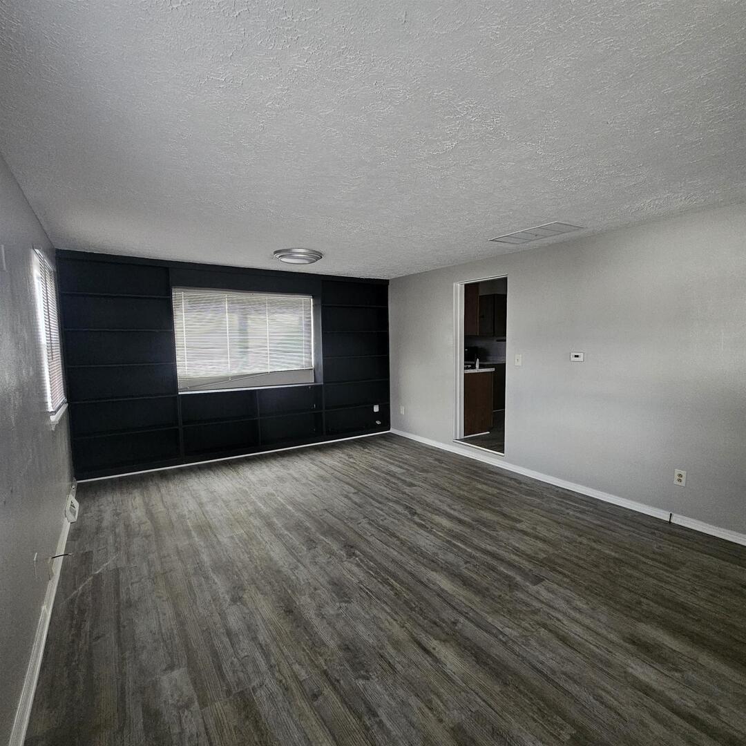 609 Airport Road Mount Vernon, IL 62864 - Photo 11 of 27 a view of an empty room with window and wooden floor