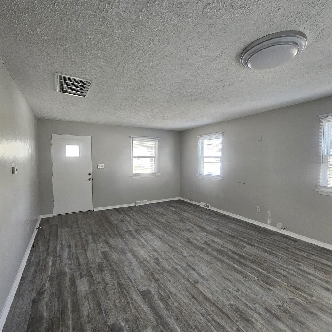 609 Airport Road Mount Vernon, IL 62864 - Photo 13 of 27 an empty room with wooden floor and windows