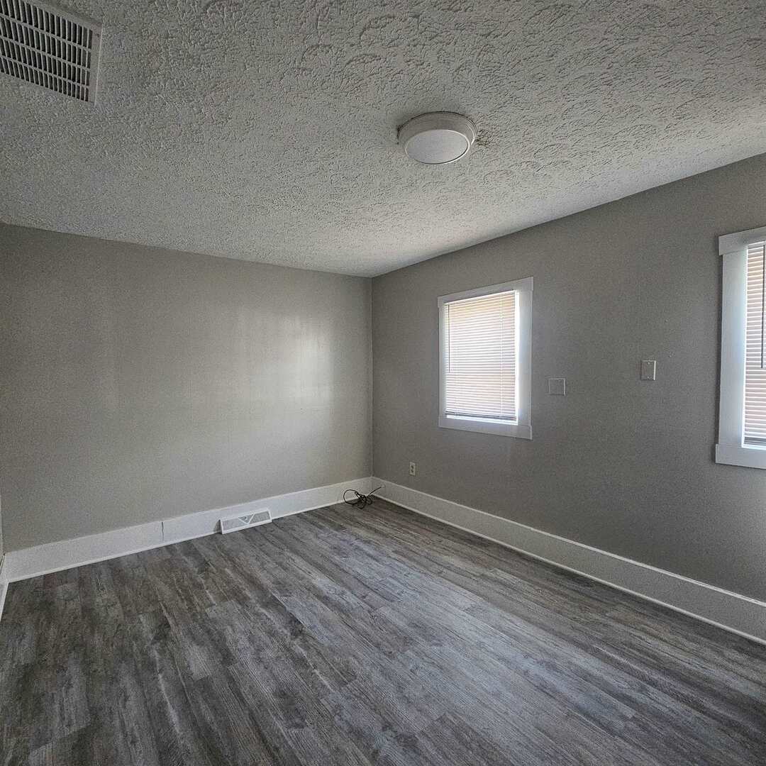 609 Airport Road Mount Vernon, IL 62864 - Photo 21 of 27 an empty room with wooden floor and windows