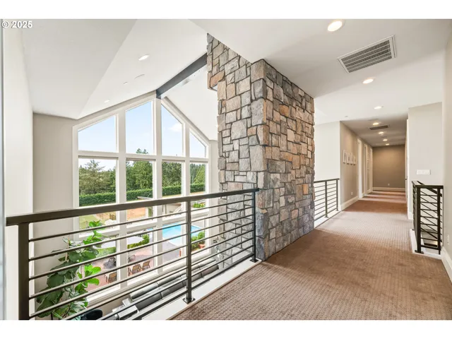 a view of a hallway with wooden floor and windows
