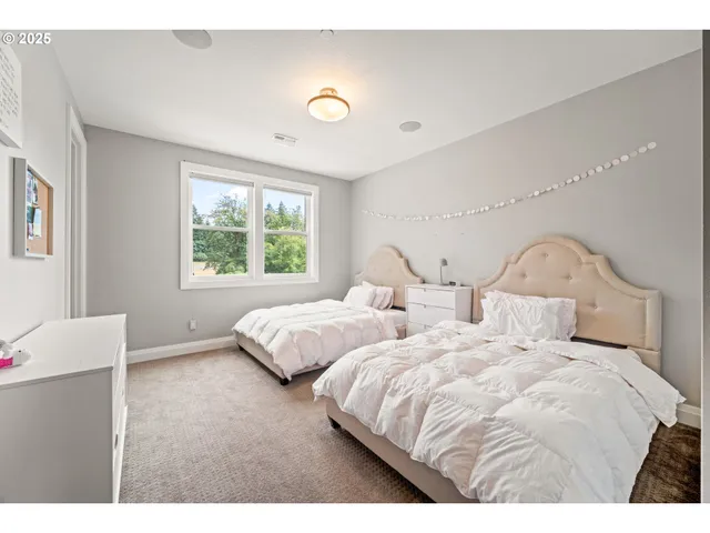 a bedroom with two beds and a window