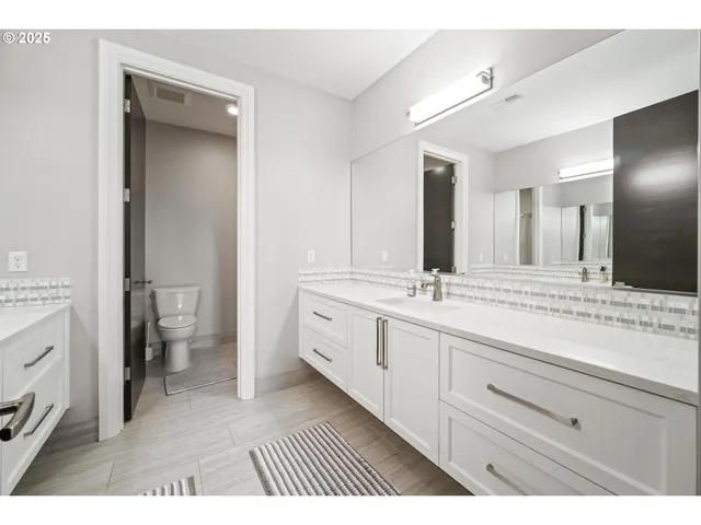 a bathroom with a double vanity sink and a mirror