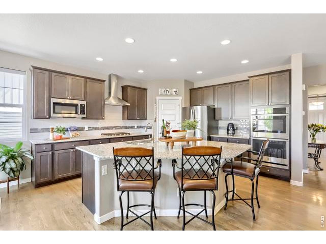 2169 Day Spring Drive Windsor, CO 80550 - Photo 9 of 39 a kitchen with stainless steel appliances kitchen island granite countertop a refrigerator a stove a sink a dining table and chairs
