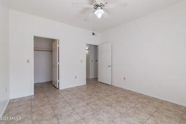 an empty room with fan and entryway