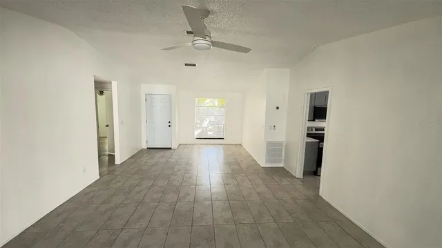 a view of a big room with wooden floor and windows