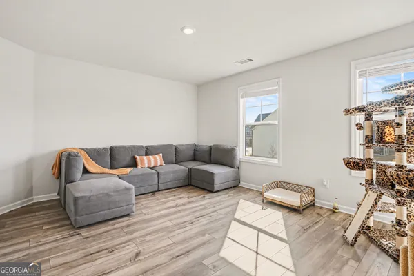 a living room with furniture and a wooden floor