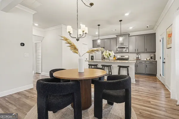 a kitchen with stainless steel appliances granite countertop a sink a stove a refrigerator and island with wooden floor