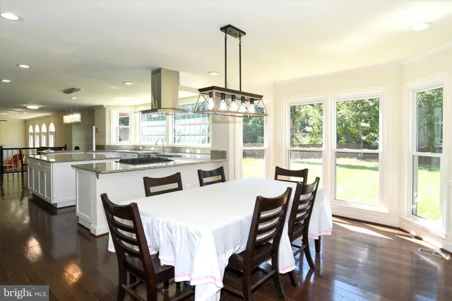 a dining room with furniture a chandelier and wooden floor