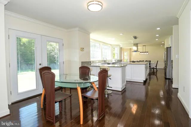 a dining area with stainless steel appliances granite countertop a table chairs refrigerator a sink and dishwasher