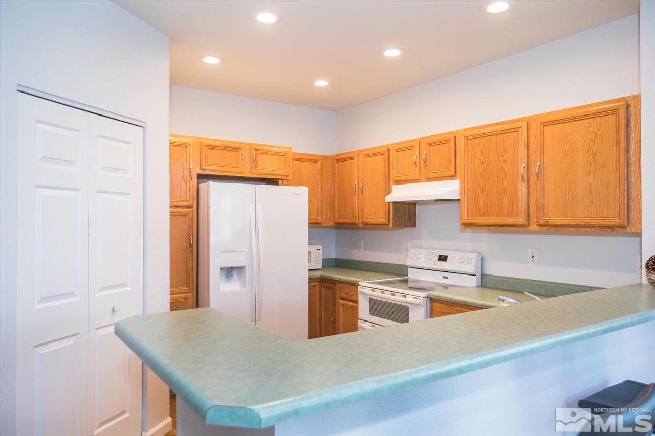700 Caughlin Glen Reno, NV 89519 - Photo 9 of 25 a kitchen with stainless steel appliances granite countertop a sink dishwasher and a refrigerator with wooden floor