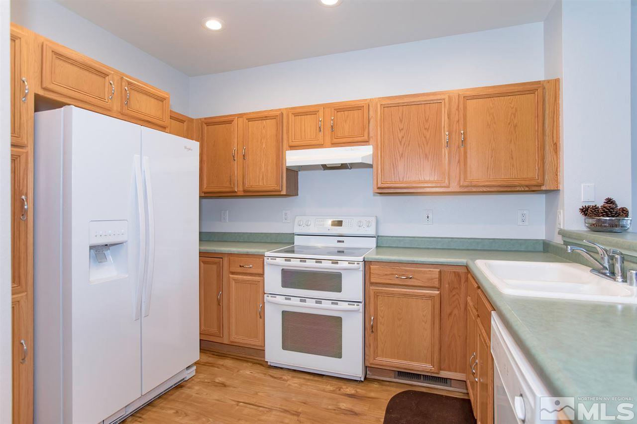 700 Caughlin Glen Reno, NV 89519 - Photo 10 of 25 a kitchen with stainless steel appliances granite countertop a sink and a refrigerator