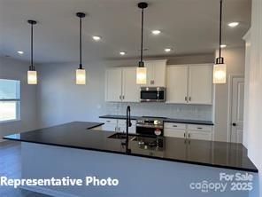 6209 Busch Way Midland, NC 28107 - Photo 8 of 17 a kitchen with stainless steel appliances granite countertop a sink a stove and a wooden floors