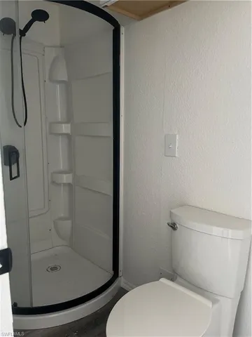 a white toilet sitting next to a shower