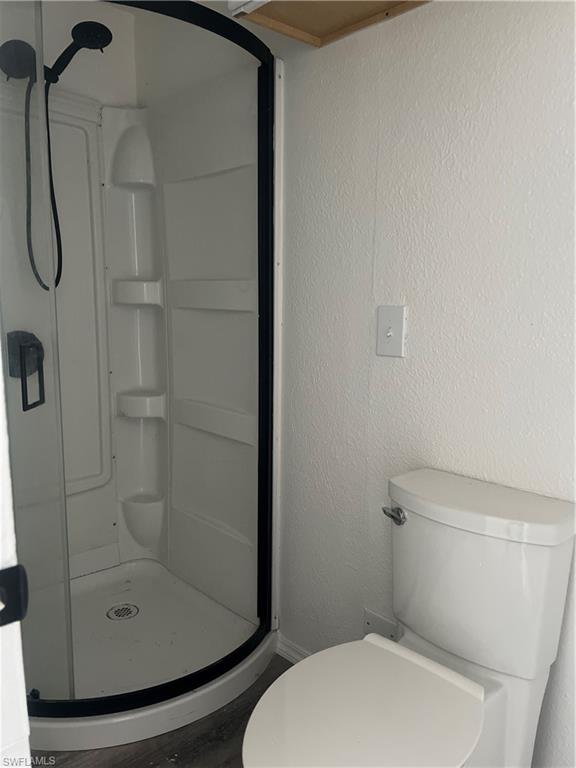 777 Walkerbilt Road, Unit 9 Naples, FL 34110 - Photo 11 of 17 a white toilet sitting next to a shower