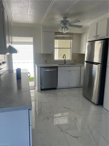 a kitchen with a sink a refrigerator and window