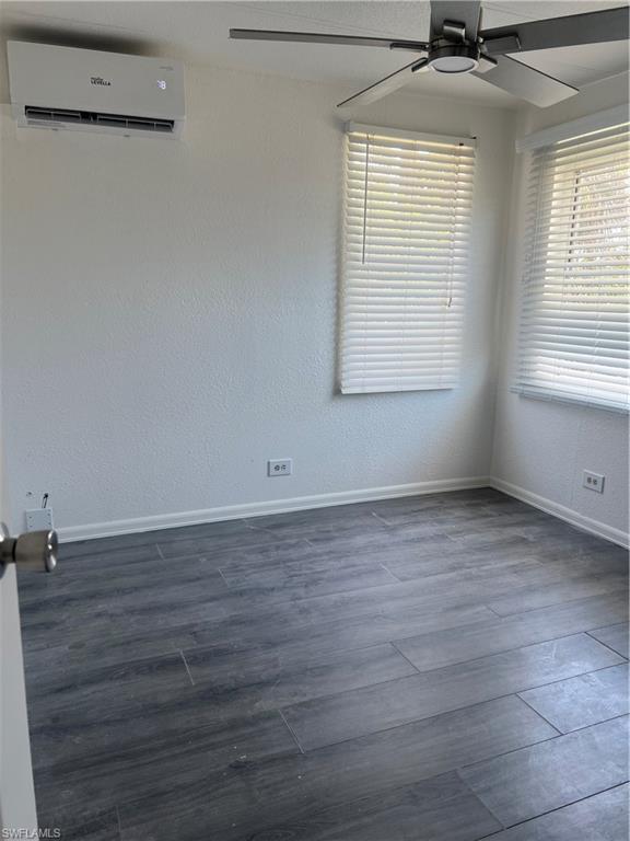 777 Walkerbilt Road, Unit 9 Naples, FL 34110 - Photo 8 of 17 an empty room with wooden floor and windows