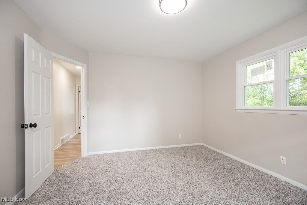 22210 Emery Road Cleveland, OH 44128 - Photo 16 of 32 Empty room featuring light carpet and baseboards