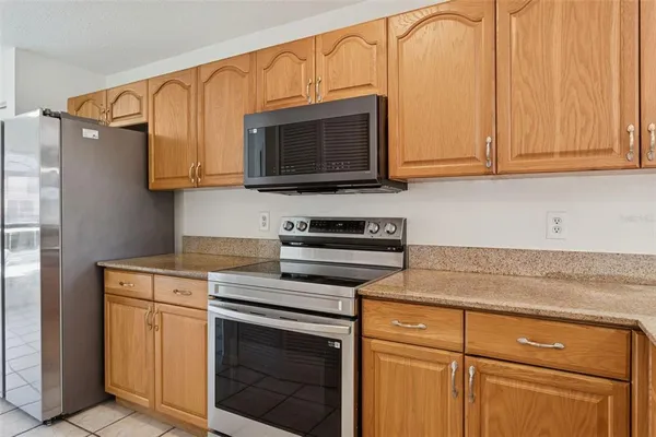 a kitchen with stainless steel appliances granite countertop white cabinets and a stove top oven