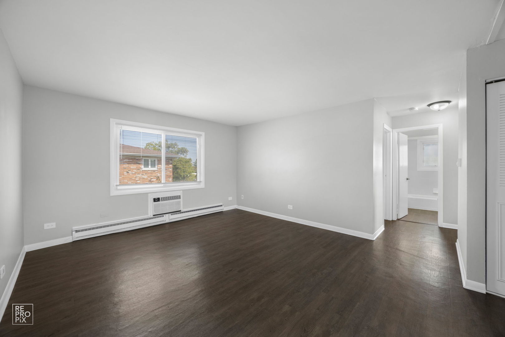 6315 Joliet Road, Unit 6 Countryside, IL 60525 - Photo 2 of 10 an empty room with wooden floor and windows
