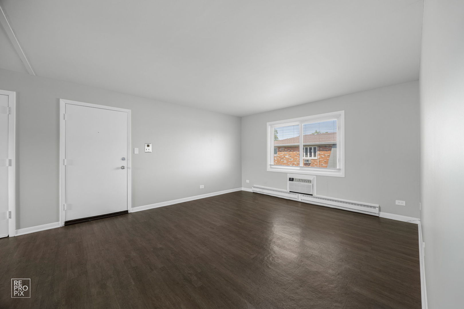 6315 Joliet Road, Unit 6 Countryside, IL 60525 - Photo 6 of 10 an empty room with wooden floor and windows