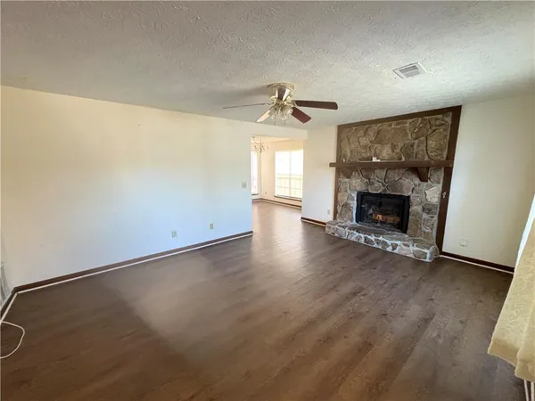 an empty room with windows and fireplace