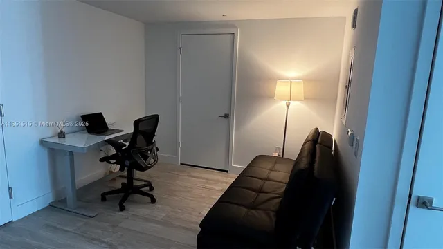 a view of a workspace with furniture and a window