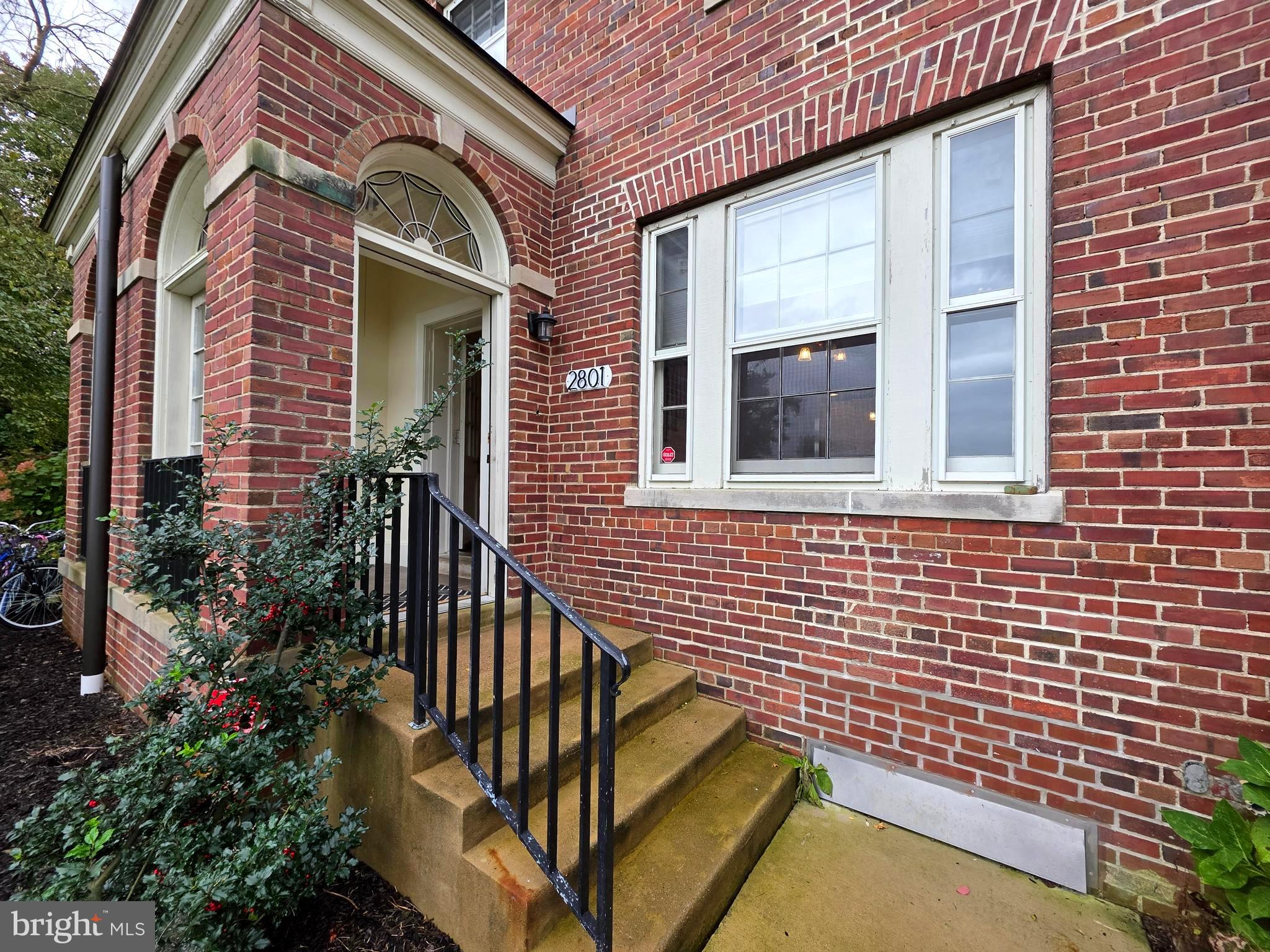 a view of a brick house with plants and wooden floor