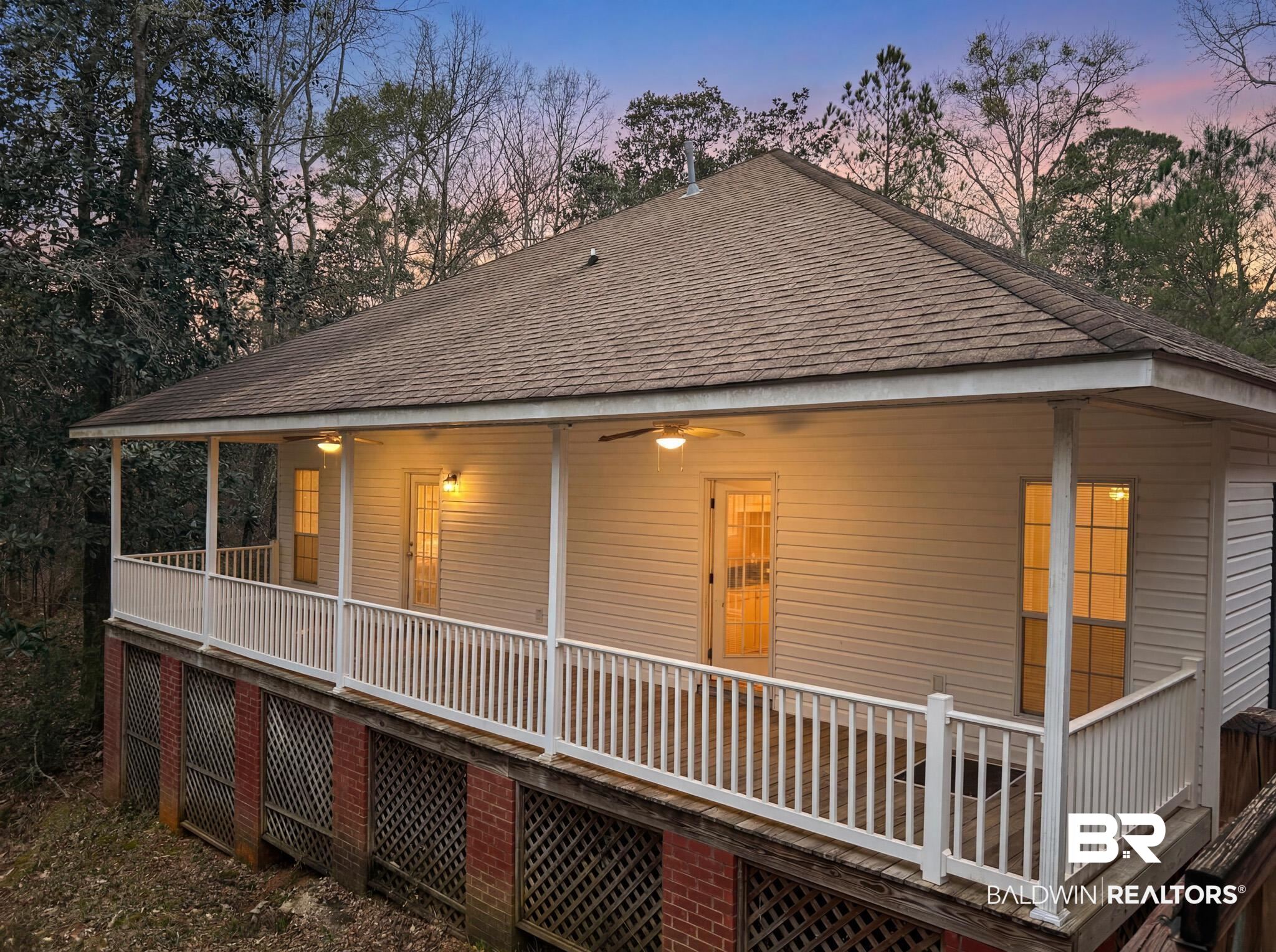 8008 Patricks Landing Road Bay Minette, AL 36507 - Photo 3 of 33 Elevated back porch with white railing, ceiling fans, and illuminated glass-paneled doors