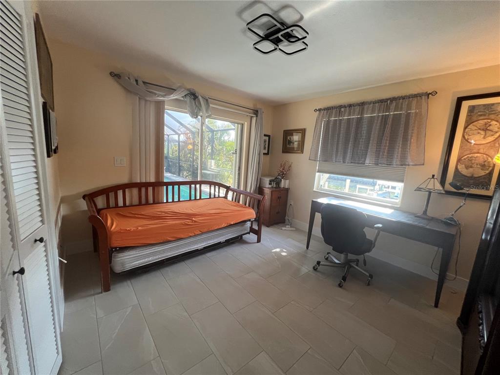 2533 Rio Tiber Drive Punta Gorda, FL 33950 - Photo 27 of 43 a bedroom with a bed and a chandelier