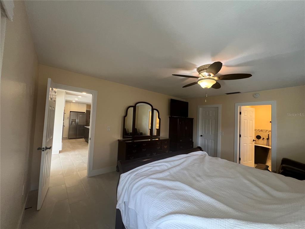 2533 Rio Tiber Drive Punta Gorda, FL 33950 - Photo 32 of 43 a bedroom with a bed and a chandelier