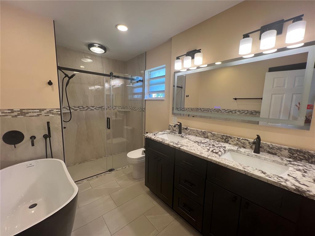 2533 Rio Tiber Drive Punta Gorda, FL 33950 - Photo 33 of 43 a bathroom with a granite countertop sink a toilet a mirror and bathtub
